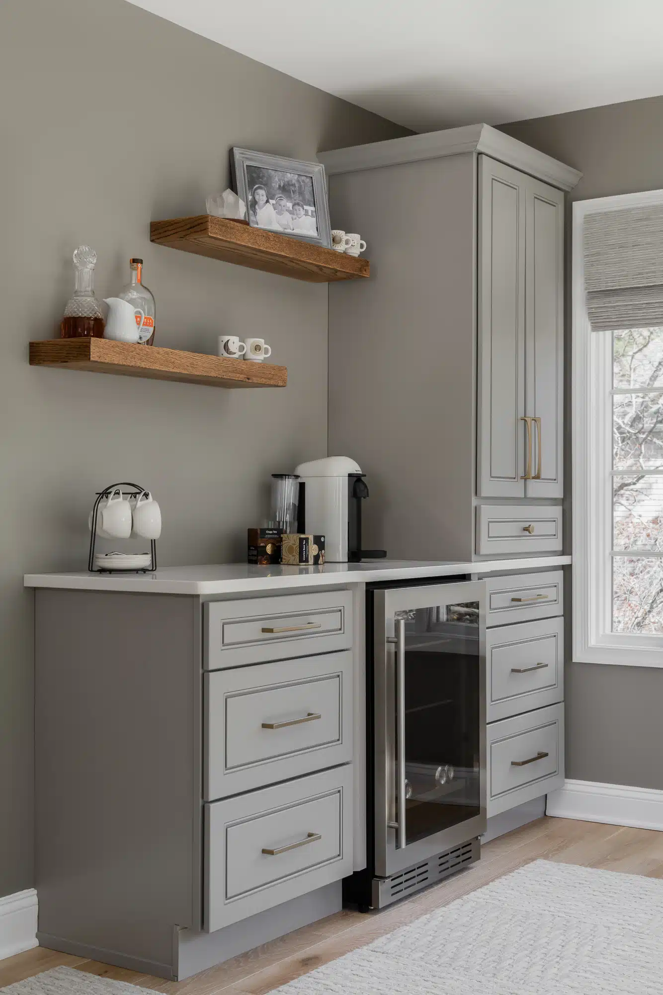 Coffee bar area in MEdford, New JErsey bedroom sitting area with beverage fridge, quartz counters, greige cabinets and floating shelves