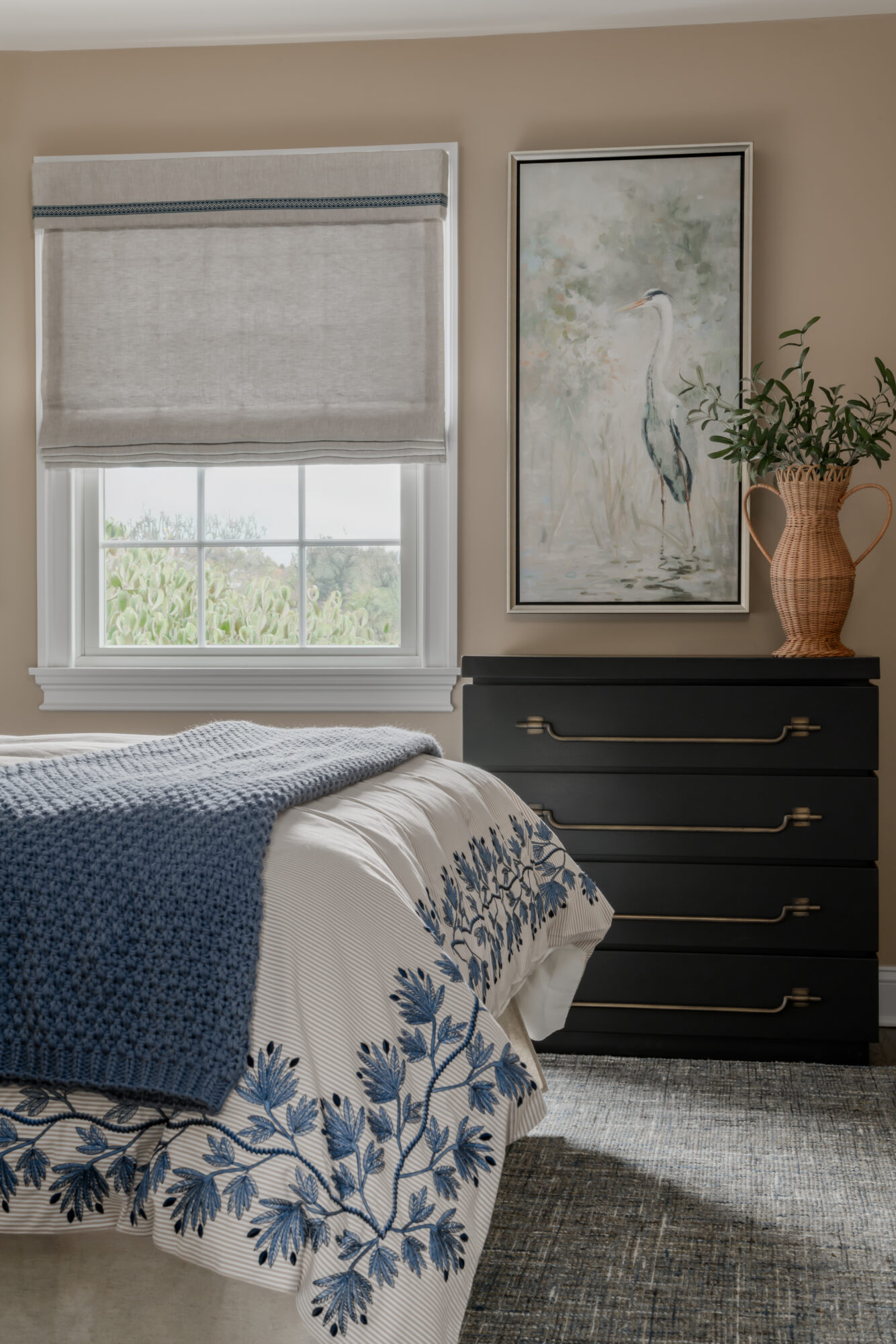 Marlton, New Jersey, guest bedroom with blue embroidered cream bedding, and Uttermost black chest of drawers
