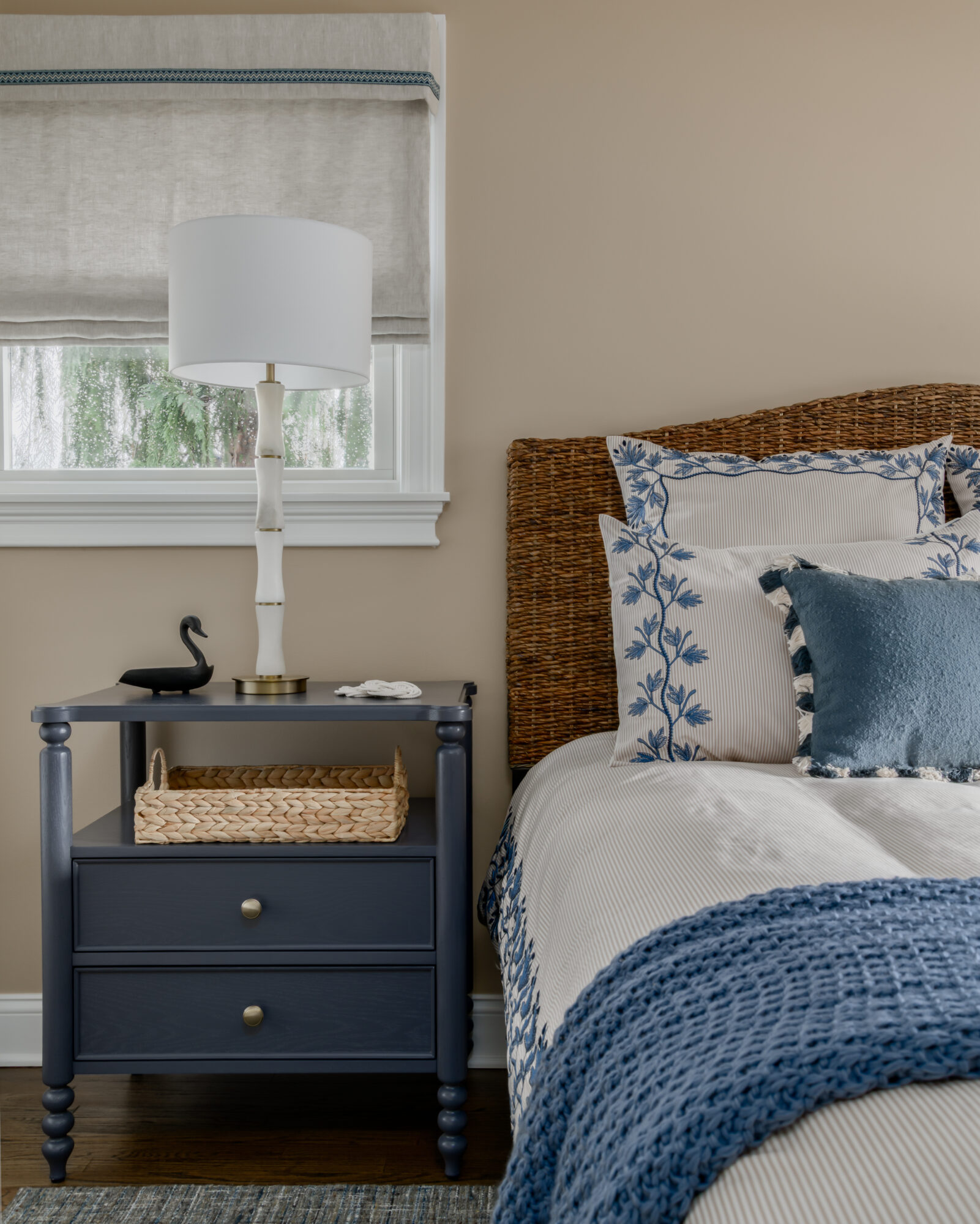 Marlton, New Jersey, guest bedroom with blue embroidered cream bedding, rattan headboard, custom Roman shade