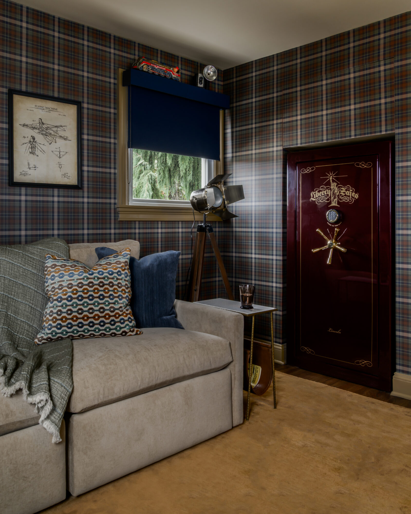 Steampunk style den with Arhaus motorized recliner, dark plaid wallpaper, and burgundy safe built into a closet, and Hunter Douglas blackout roller shades, Marlton, New Jersey