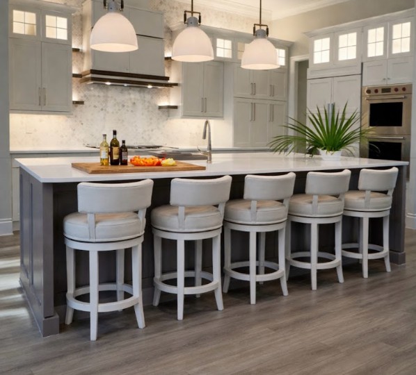Coastal kitchen renovation in Estero Florida featuring large island seating, white cabinetry, and pendant lighting